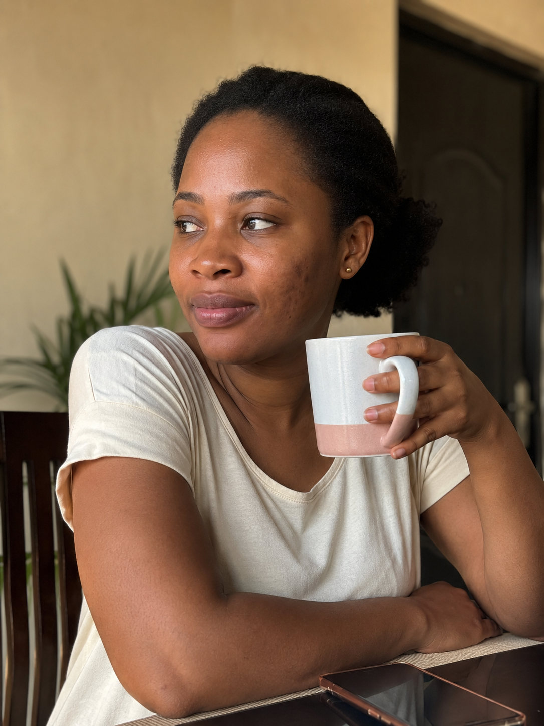 Adaeze, sitting at her dining table at home in Lagos